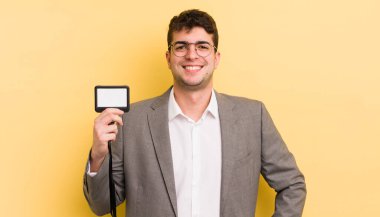 Genç yakışıklı adam mutlu bir şekilde gülümsüyor, eli kalçasında ve kendinden emin. VIP geçiş konsepti