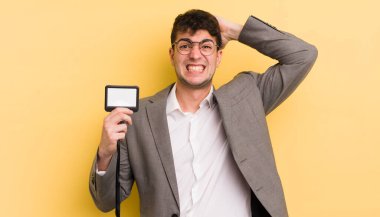 Genç ve yakışıklı bir adam stresli, endişeli ya da korkmuş hissediyor. Elleri başının üstünde. VIP geçiş konsepti