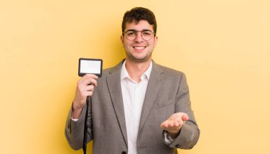 Genç ve yakışıklı bir adam arkadaşça gülümsüyor ve bir konsept sunuyor. VIP geçiş konsepti