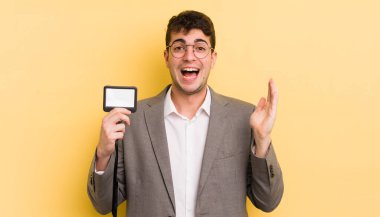 Genç yakışıklı adam kendini mutlu hissediyor ve inanılmaz bir şeye hayret ediyor. VIP geçiş konsepti