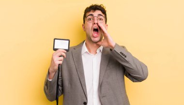 Genç yakışıklı adam mutlu hissediyor, elleri ağzının kenarında bağırıyor. VIP geçiş konsepti