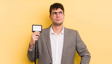 Genç yakışıklı adam omuz silkiyor, kafası karışık ve kararsız. VIP geçiş konsepti