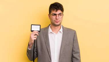 Genç ve yakışıklı bir adam üzgün, üzgün ya da kızgın hissediyor ve yan tarafa bakıyor. VIP geçiş konsepti