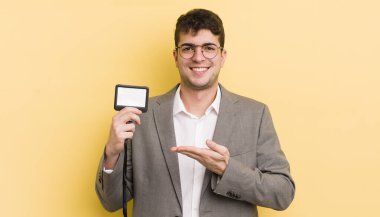 Genç yakışıklı adam neşeyle gülümsüyor, mutlu hissediyor ve bir konsept gösteriyor. VIP geçiş konsepti