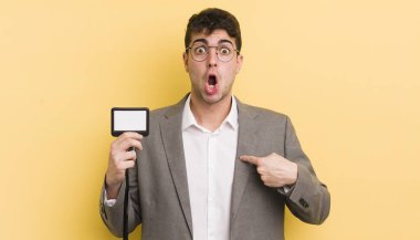 Şok olmuş ve ağzı açık, kendini işaret eden genç ve yakışıklı bir adam. VIP geçiş konsepti