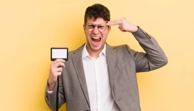 Genç yakışıklı adam mutsuz ve stresli görünüyor, intihar jesti silah işareti yapıyor. VIP geçiş konsepti