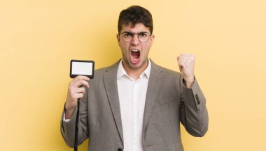 Genç yakışıklı adam sinirli bir ifadeyle agresif bir şekilde bağırıyor. VIP geçiş konsepti