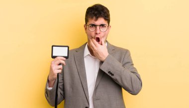 Ağzı ve gözleri açık ve eli çenesinde genç yakışıklı bir adam. VIP geçiş konsepti