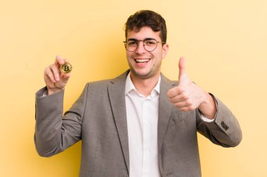 Genç ve yakışıklı bir adam gururlu, olumlu gülümsüyor. Bitcoin konsepti