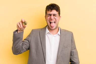 Genç, yakışıklı, neşeli ve asi tavırlı, şaka yapan ve dilini dışarı çıkaran bir adam. Bitcoin konsepti