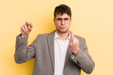 Genç ve yakışıklı bir adam sinirli, sinirli, asi ve agresif hissediyor. Bitcoin konsepti