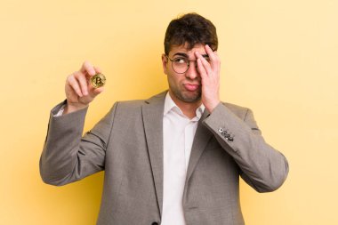Genç yakışıklı bir adam bıkkın, hayal kırıklığına uğramış ve yorucu bir geceden sonra uykulu hissediyor. Bitcoin konsepti