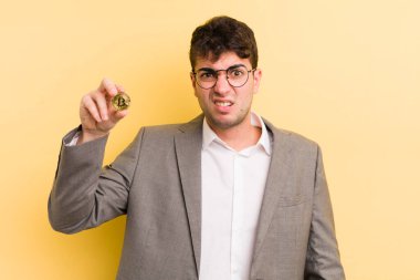 Genç yakışıklı adam şaşkın ve şaşkın hissediyor. Bitcoin konsepti