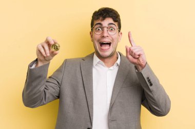 Genç yakışıklı bir adam bir fikri fark ettikten sonra mutlu ve heyecanlı bir dahi gibi hissediyor. Bitcoin konsepti