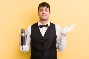 Genç yakışıklı adam şaşkın, şaşkın ve şüpheci hissediyor. barmen kokteyli