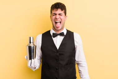 Genç, yakışıklı, neşeli ve asi tavırlı, şaka yapan ve dilini dışarı çıkaran bir adam. barmen kokteyli