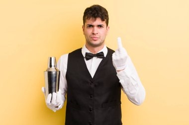 Genç ve yakışıklı bir adam sinirli, sinirli, asi ve agresif hissediyor. barmen kokteyli