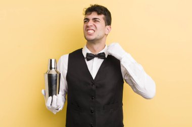 Genç ve yakışıklı adam stresli, endişeli, yorgun ve hayal kırıklığına uğramış hissediyor. barmen kokteyli