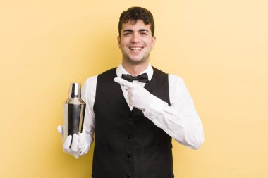 Genç yakışıklı adam heyecanlı ve şaşırmış görünüyor. barmen kokteyli