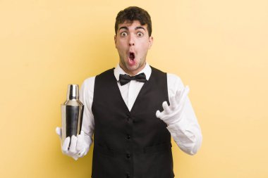 Genç yakışıklı adam, inanılmaz bir sürprizle şaşkına dönmüş ve hayrete düşmüştü. barmen kokteyli