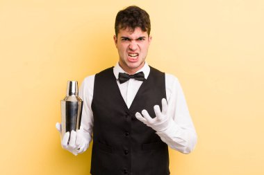 Genç ve yakışıklı bir adam sinirli, sinirli ve sinirli görünüyor. barmen kokteyli