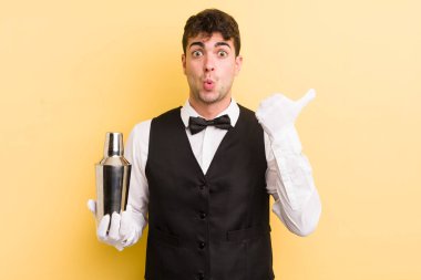 İnanamadığı için şaşırmış genç ve yakışıklı bir adam. barmen kokteyli