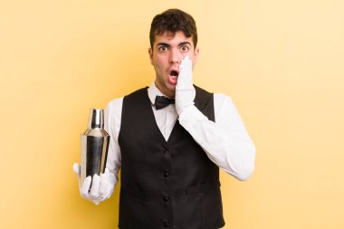 Genç ve yakışıklı bir adam şok olmuş ve korkmuş hissediyor. barmen kokteyli