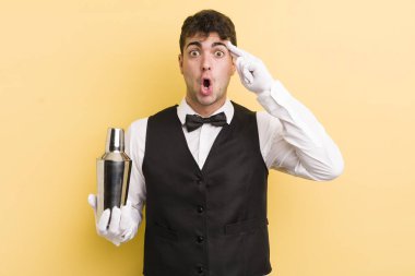 Genç yakışıklı adam şaşırmış görünüyor, yeni bir düşünce, fikir ya da konsept fark ediyor. barmen kokteyli