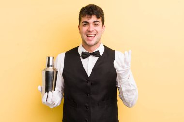 Genç yakışıklı adam kendini mutlu hissediyor, bir çözüm ya da fikir bulduğuna şaşırıyor. barmen kokteyli
