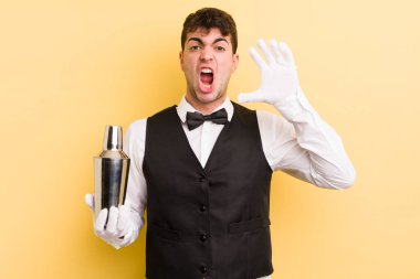 Genç yakışıklı adam ellerini havaya kaldırarak çığlık atıyor. barmen kokteyli