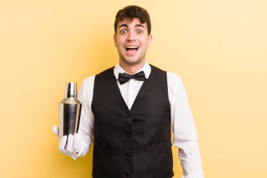Genç yakışıklı adam mutlu ve hoş bir şekilde şaşırmış görünüyor. barmen kokteyli