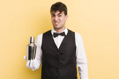 Genç yakışıklı adam şaşkın ve şaşkın hissediyor. barmen kokteyli