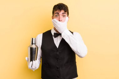 Genç ve yakışıklı bir adam elleri ile ağzını kapatıyor ve şok geçiriyor. barmen kokteyli