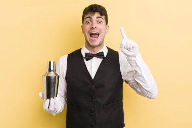 Genç yakışıklı bir adam bir fikri fark ettikten sonra mutlu ve heyecanlı bir dahi gibi hissediyor. barmen kokteyli