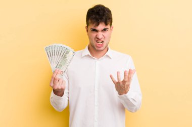 Genç ve yakışıklı bir adam sinirli, sinirli ve sinirli görünüyor. para kavramı