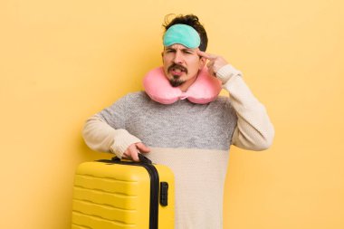 Genç yakışıklı adam kafası karışık ve şaşkın hissediyor, deli olduğunu gösteriyor. seyahat yolcu kavramı
