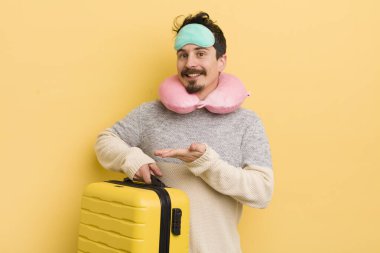 Genç yakışıklı adam neşeyle gülümsüyor, mutlu hissediyor ve bir konsept gösteriyor. seyahat yolcu kavramı