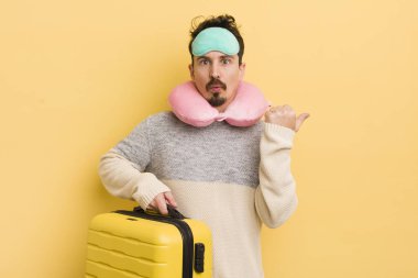 İnanamadığı için şaşırmış genç ve yakışıklı bir adam. seyahat yolcu kavramı