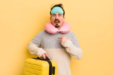 Şok olmuş ve ağzı açık, kendini işaret eden genç ve yakışıklı bir adam. seyahat yolcu kavramı