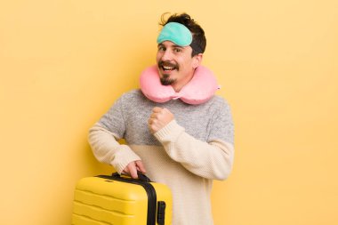 Genç yakışıklı adam kendini mutlu hissediyor ve bir meydan okumayla yüzleşiyor ya da kutluyor. seyahat yolcu kavramı