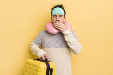 Genç ve yakışıklı bir adam elleri ile ağzını kapatıyor ve şok geçiriyor. seyahat yolcu kavramı