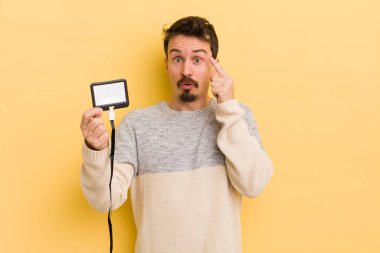 Genç yakışıklı adam şaşırmış görünüyor, yeni bir düşünce, fikir ya da konsept fark ediyor. VIP geçiş kartı