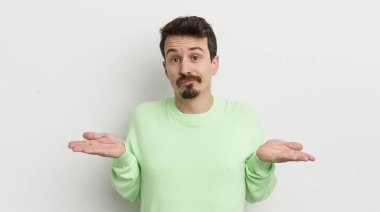 Genç yakışıklı adam şaşkın, şaşkın ve şüpheci hissediyor.