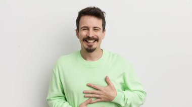 Genç yakışıklı adam komik bir şakaya yüksek sesle gülüyor.