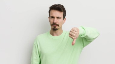 Genç ve yakışıklı adam kendini kötü hissediyor, baş parmağını kaldırıyor.