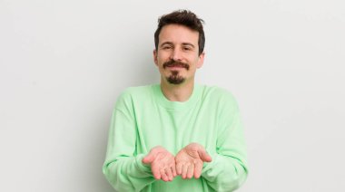 Genç yakışıklı adam mutlu bir şekilde gülümsüyor.