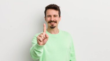 Genç yakışıklı adam gururla gülümsüyor ve kendinden emin bir numara oluyor.