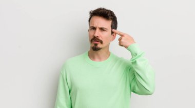 Genç yakışıklı adam kafası karışık ve şaşkın hissediyor, deli olduğunu gösteriyor.