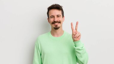 Genç yakışıklı adam gülümsüyor ve arkadaş canlısı görünüyor.