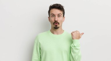 İnançsızlığa şaşırmış genç yakışıklı bir adam.